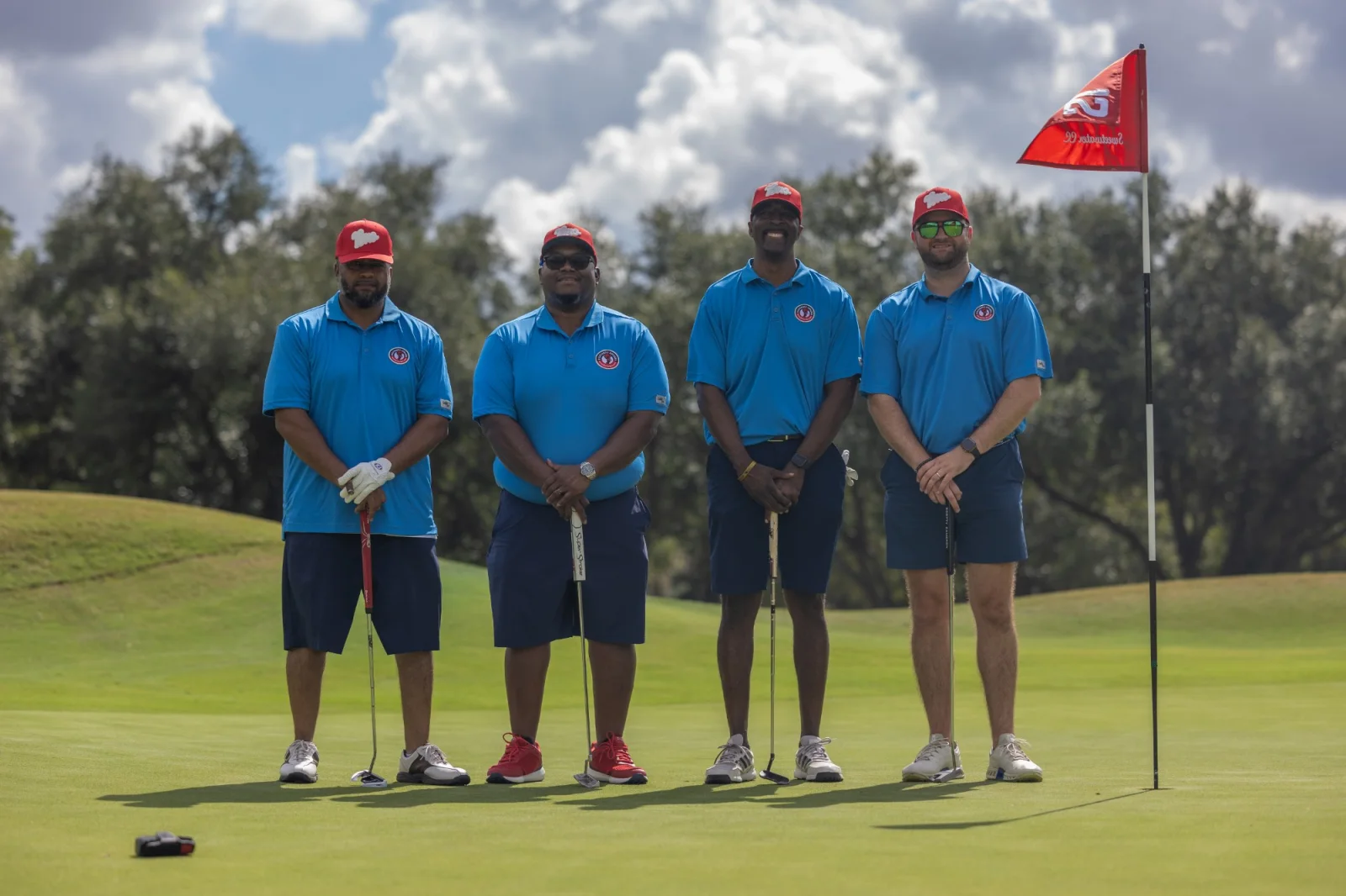 Three golfers photographed at the pin
