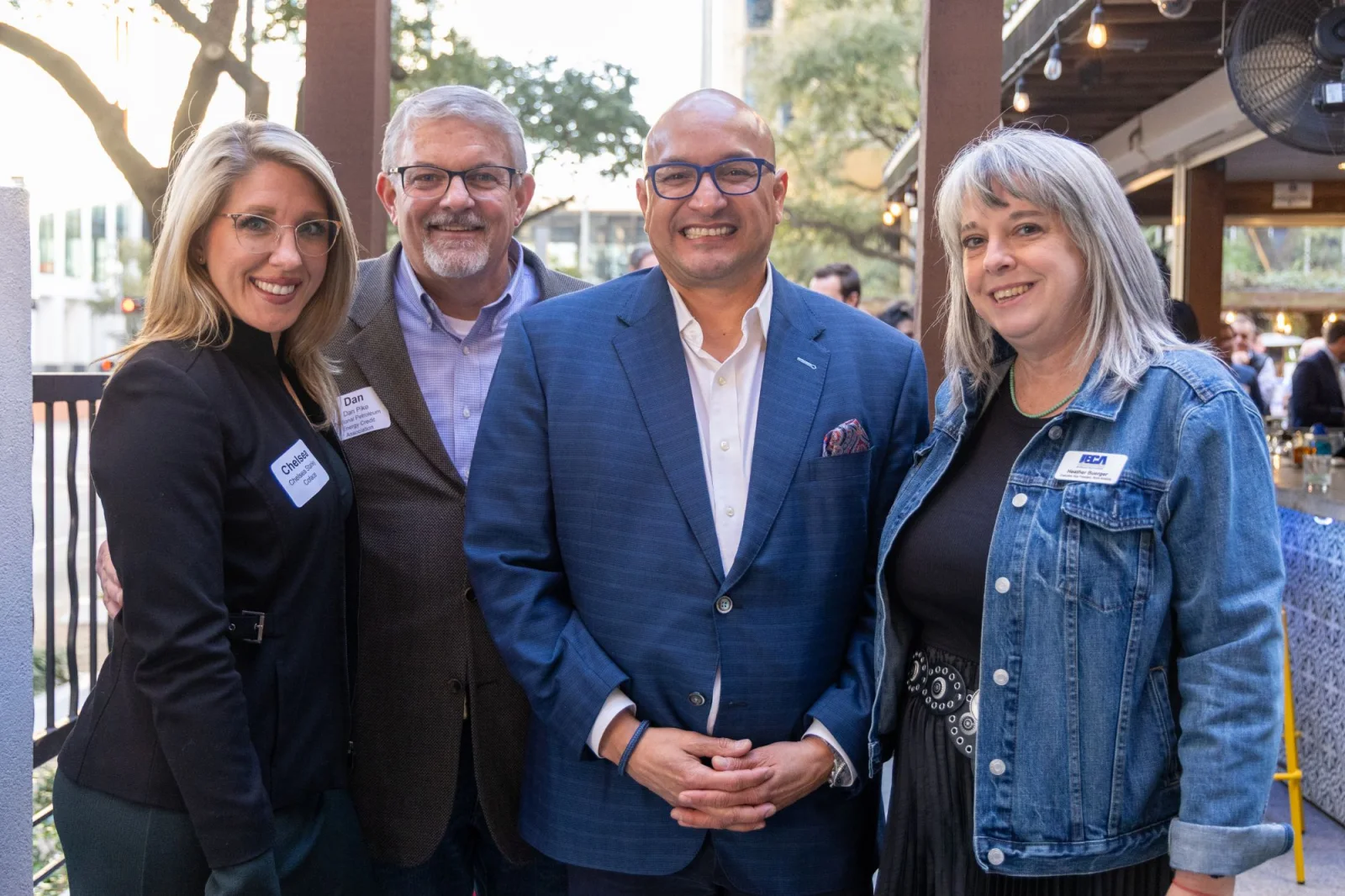 Group of four photographed with name badges at a networking reception
