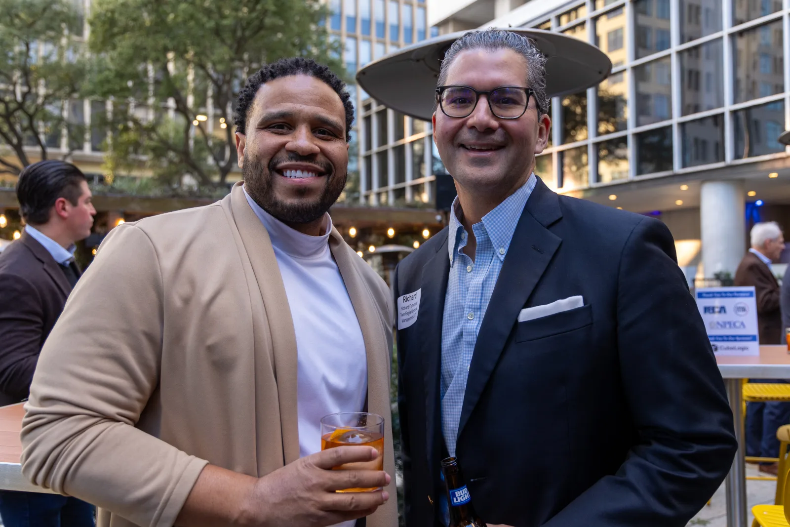 Two members posed together in warm evening light at an NPECA reception