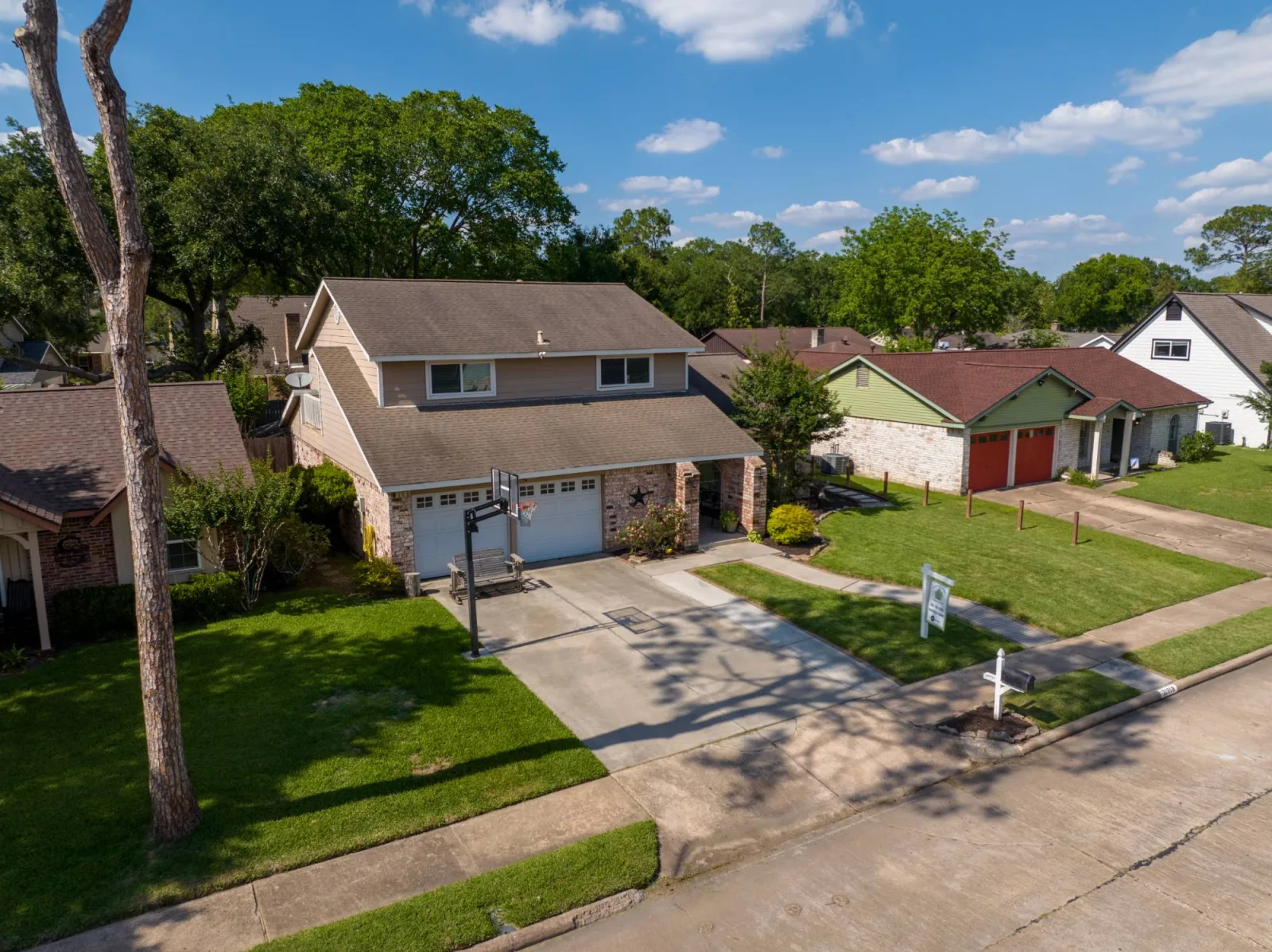 Drone aerial three-quarter view of a Meadows Place home and its street